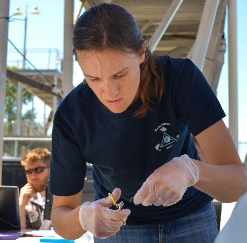 Graduate student performs fish surgery